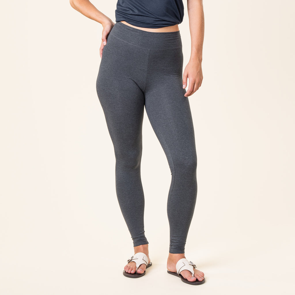 Person wearing grey organic cotton leggings on a plain background