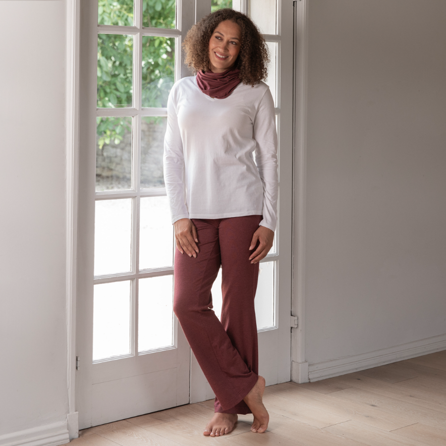 Woman wearing a white long-sleeve top and mulberry organic cotton pants 